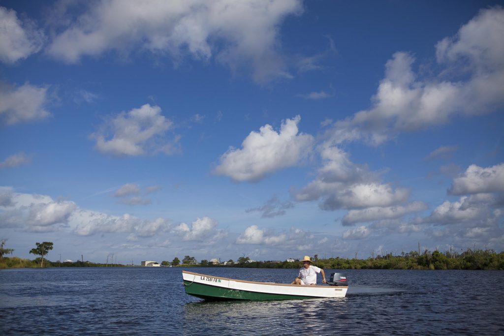 A man is seen on a boat in one of the lakes in the Greater New Orleans area