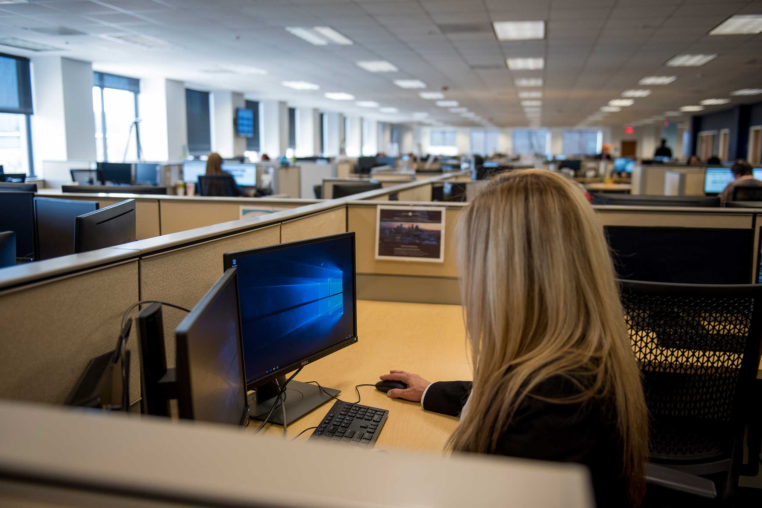 A worker sits in her cubicle