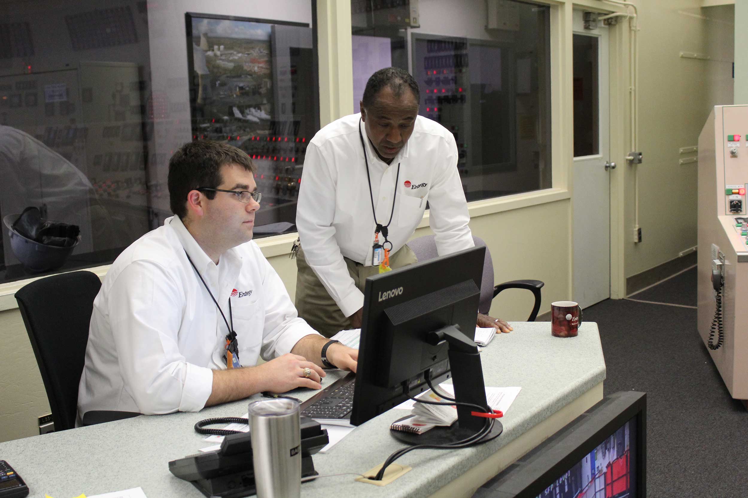Two Entergy employees collaborate together on work
